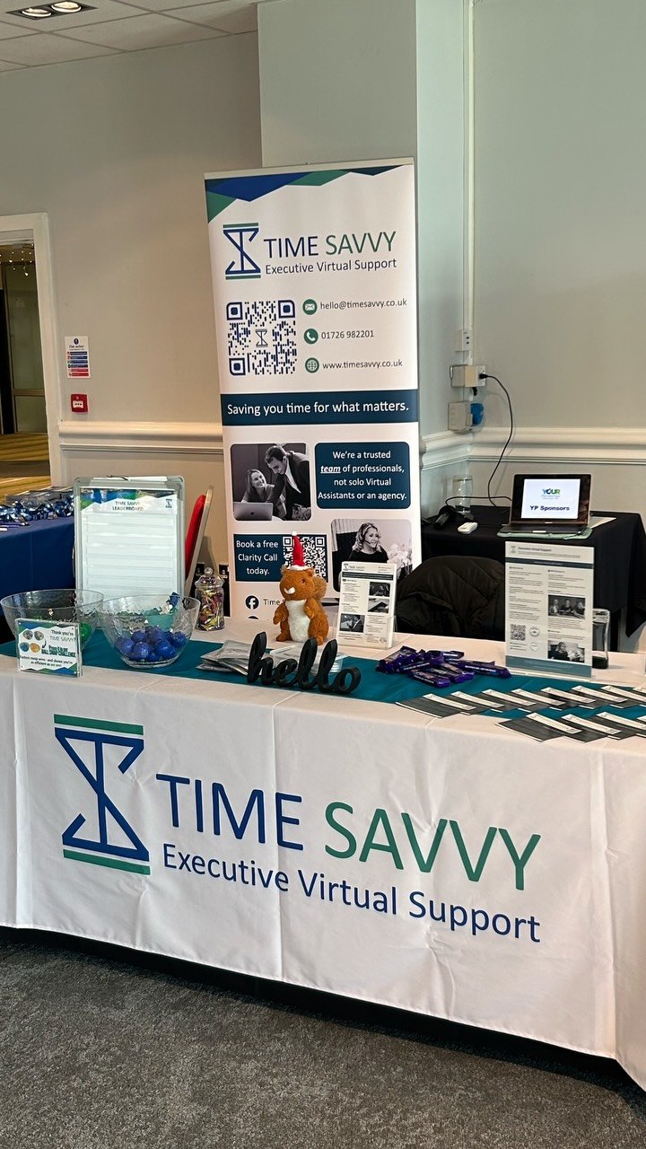 The Time Savvy stand at a networking event, with branded banner, toolkits and resources on the table