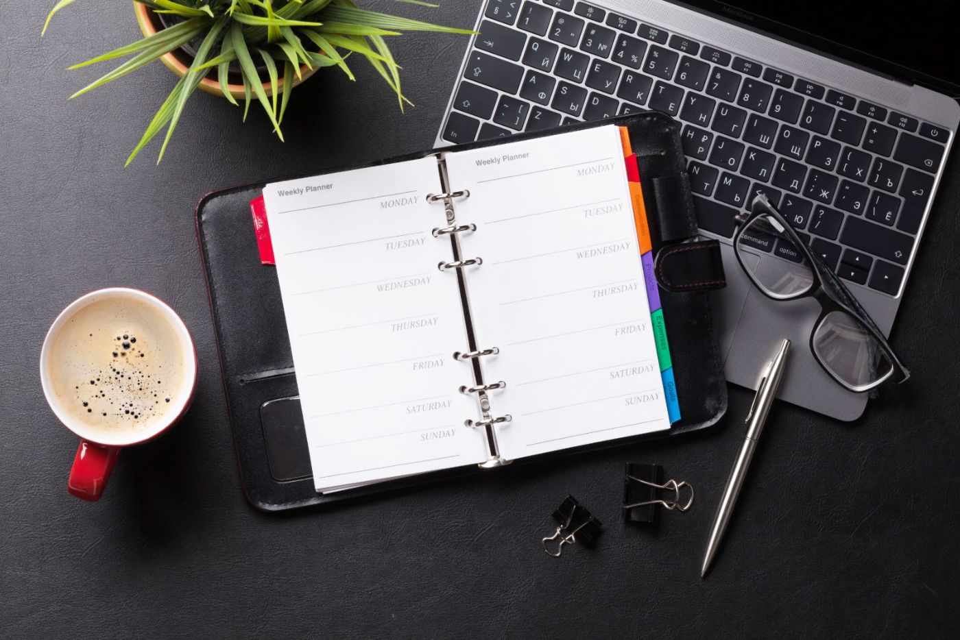 Organised workspace with planner, laptop and coffee